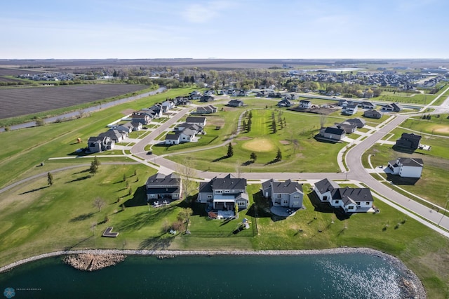 aerial view of property and surrounding area featuring a large body of water and nearby suburban area