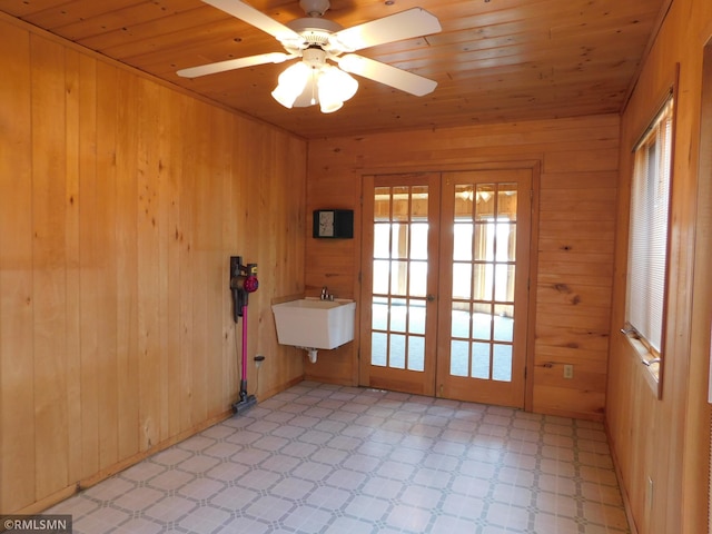 32598 Pioneer Ave, Aitkin, MN 56431 - spare room with french doors, a sink, light flooring, wooden walls, and a ceiling fan