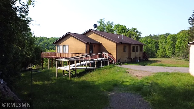 32598 Pioneer Ave, Aitkin, MN 56431 - back of property with a deck, a lawn, and a wooded view
