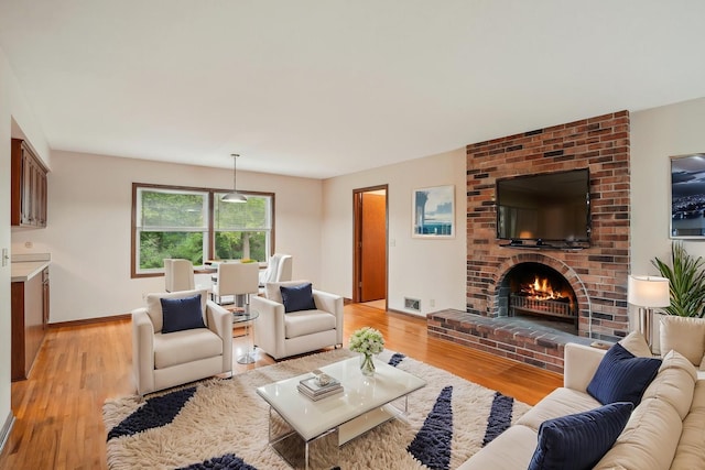 3529 Jerry St, White Bear Lake, MN 55110 - living room featuring light wood-type flooring, a fireplace, and baseboards