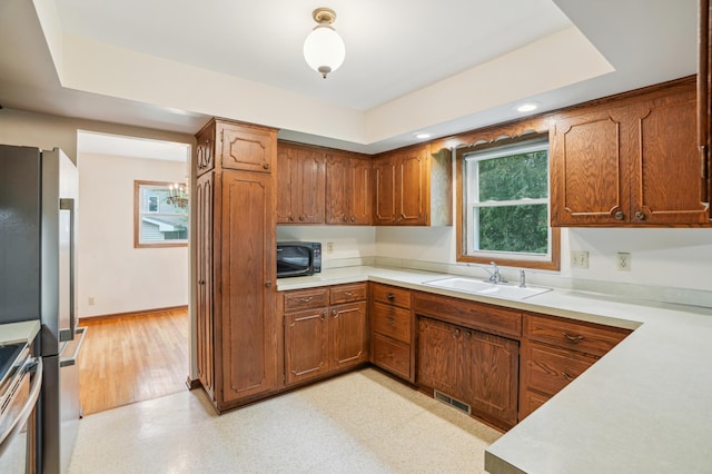 3529 Jerry St, White Bear Lake, MN 55110 - kitchen featuring a sink, light countertops, stainless steel appliances, brown cabinets, and recessed lighting