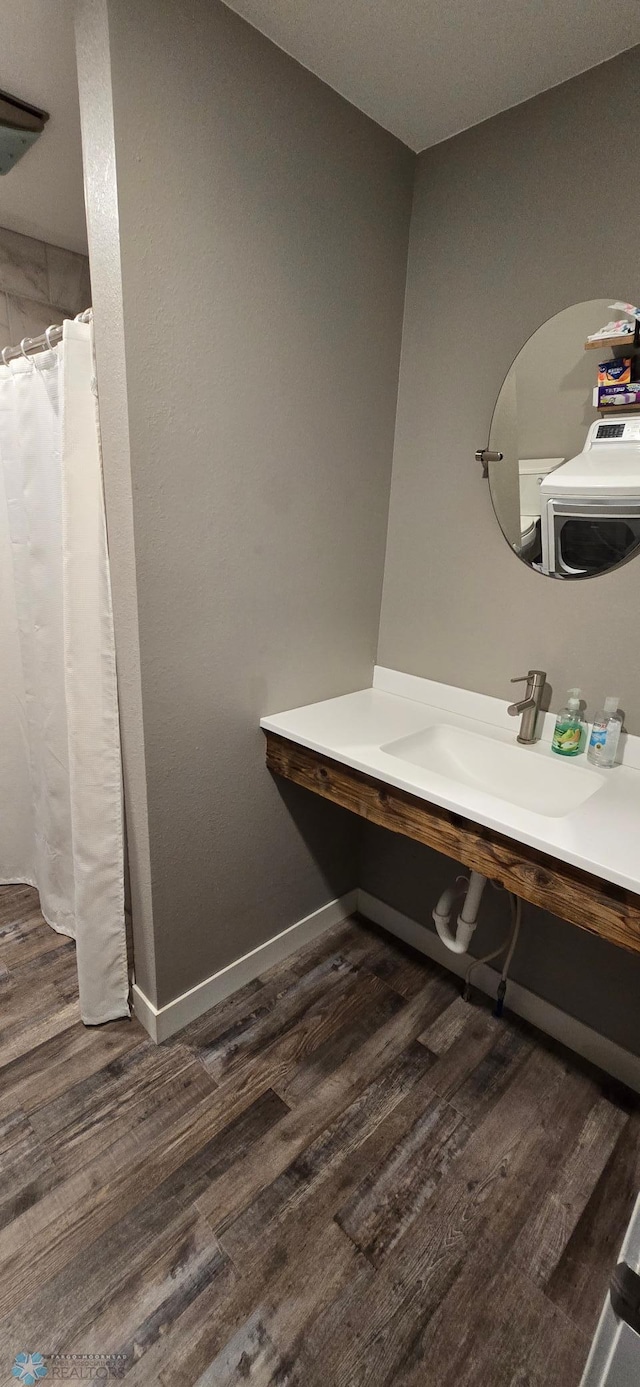 304 1st Ave E, Halstad, MN 56548 - full bath with wood finished floors, a shower with curtain, vanity, and baseboards