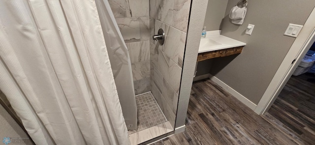 304 1st Ave E, Halstad, MN 56548 - bathroom with wood finished floors, a tile shower, and baseboards