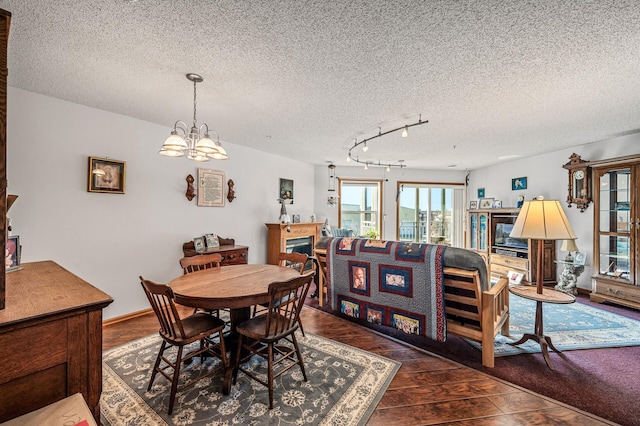 2231 Penn Pl Unit 114, North Saint Paul, MN 55109 - dining area with a textured ceiling, wood finished floors, a chandelier, and track lighting
