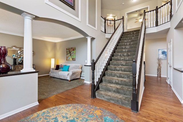 13148 Crolly Ct, Rosemount, MN 55068 - staircase with decorative columns, wood finished floors, arched walkways, ceiling fan, and baseboards