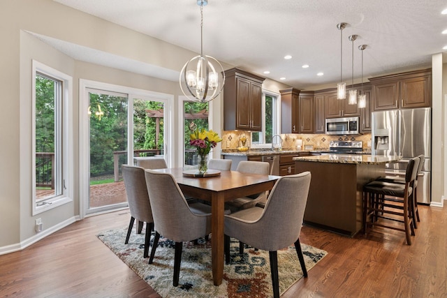 13148 Crolly Ct, Rosemount, MN 55068 - dining area with a chandelier, plenty of natural light, baseboards, wood finished floors, and recessed lighting
