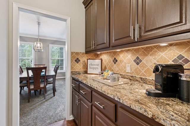13148 Crolly Ct, Rosemount, MN 55068 - kitchen featuring crown molding, tasteful backsplash, light stone counters, dark colored carpet, and baseboards