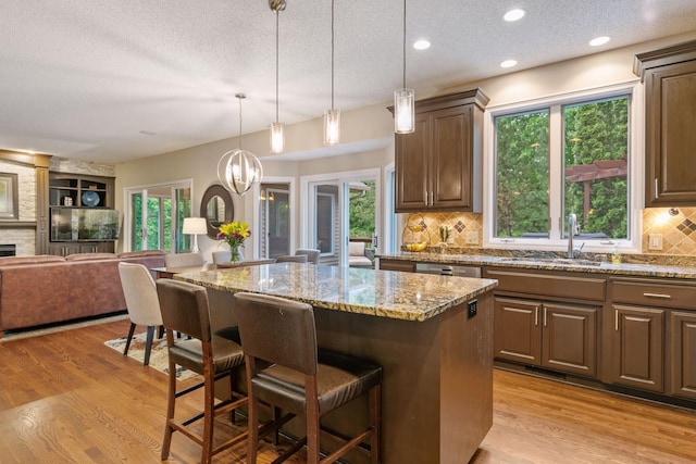 13148 Crolly Ct, Rosemount, MN 55068 - kitchen featuring a textured ceiling, a sink, a kitchen bar, open floor plan, and a center island