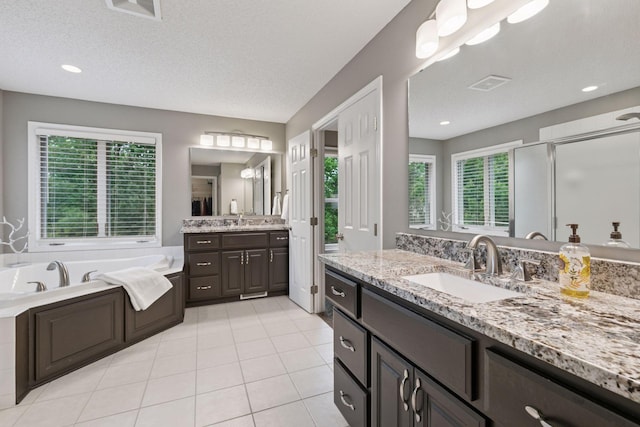 13148 Crolly Ct, Rosemount, MN 55068 - full bath with two vanities, a bath, a stall shower, tile patterned floors, and recessed lighting