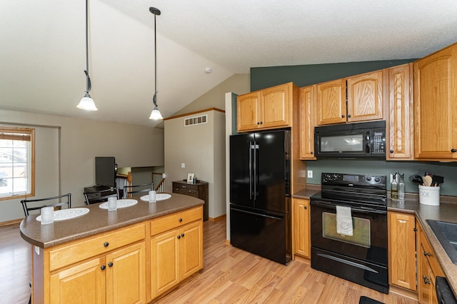 kitchen with black appliances, light wood-type flooring, lofted ceiling, decorative light fixtures, and dark countertops
