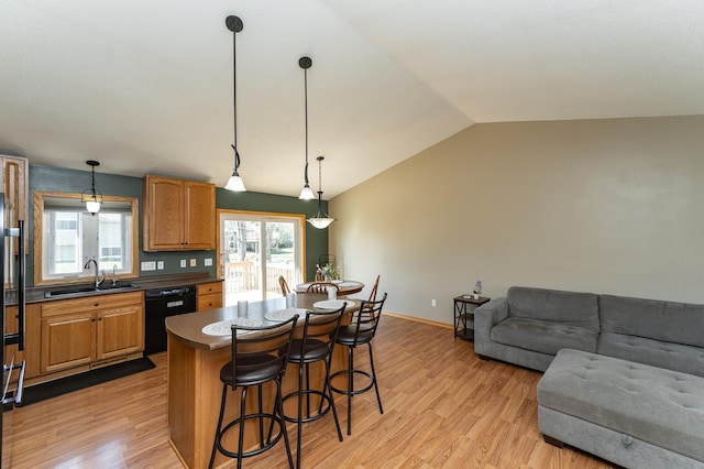 kitchen featuring a sink, black dishwasher, a kitchen bar, dark countertops, and vaulted ceiling