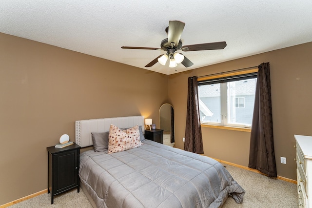 bedroom featuring light carpet, baseboards, and a ceiling fan