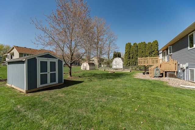 view of green lawn with a storage unit, an outdoor structure, cooling unit, and a deck