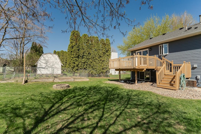 view of yard featuring a wooden deck, a fire pit, stairway, central air condition unit, and an outbuilding