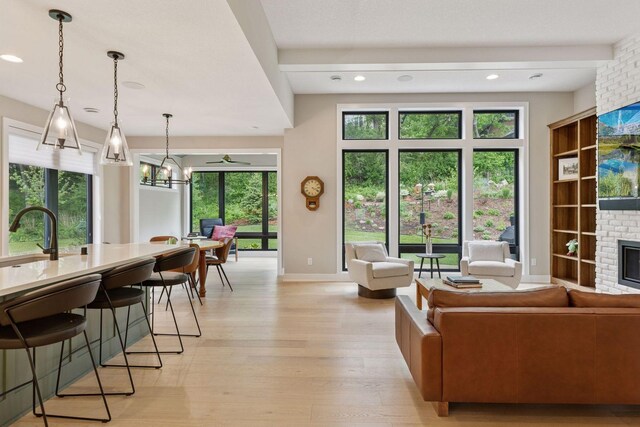 16798 Stirrup Ln, Eden Prairie, MN 55347 - living room with a brick fireplace, light wood finished floors, baseboards, recessed lighting, and a chandelier