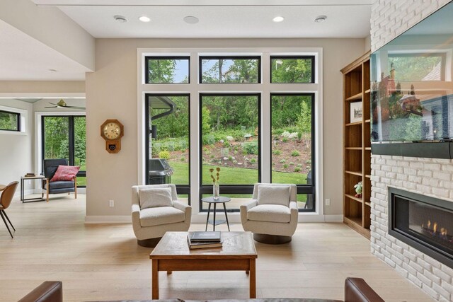 16798 Stirrup Ln, Eden Prairie, MN 55347 - living room with a fireplace, light wood-type flooring, baseboards, a ceiling fan, and recessed lighting