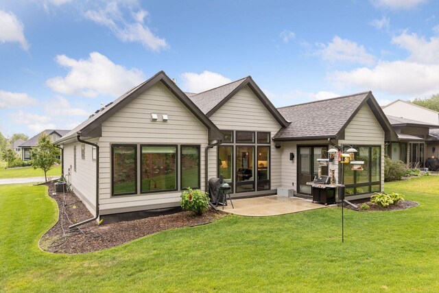 16798 Stirrup Ln, Eden Prairie, MN 55347 - rear view of house with a patio, a yard, a shingled roof, and a sunroom