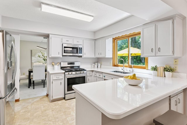 7010 Tartan Curv, Eden Prairie, MN 55346 - kitchen featuring appliances with stainless steel finishes, a peninsula, light countertops, and white cabinets