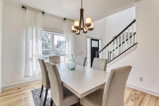 1730 Deephaven Dr, Woodbury, MN 55129 - dining area featuring a chandelier, wood-type flooring, baseboards, a textured ceiling, and stairway