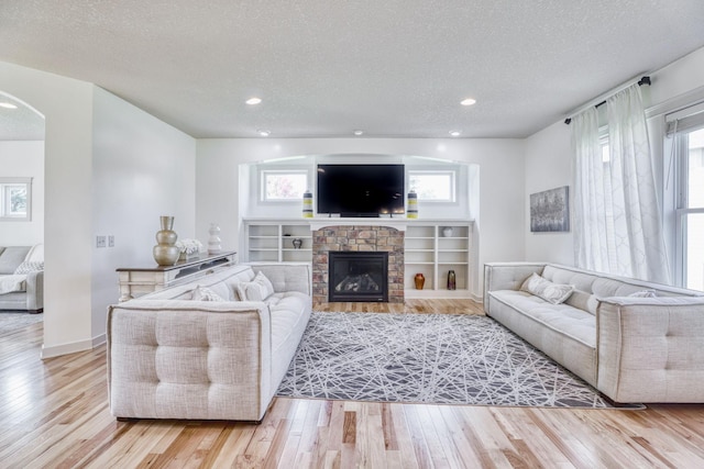 1730 Deephaven Dr, Woodbury, MN 55129 - living area featuring a textured ceiling, wood finished floors, healthy amount of natural light, recessed lighting, and arched walkways