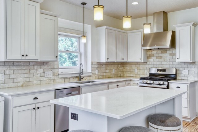 1730 Deephaven Dr, Woodbury, MN 55129 - kitchen with stainless steel appliances, wall chimney exhaust hood, a sink, a breakfast bar, and white cabinetry