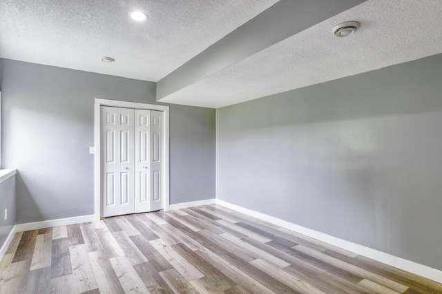 1730 Deephaven Dr, Woodbury, MN 55129 - unfurnished bedroom featuring a textured ceiling, wood finished floors, baseboards, a closet, and recessed lighting
