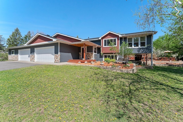 view of front of house featuring a garage, driveway, a front yard, and stone siding