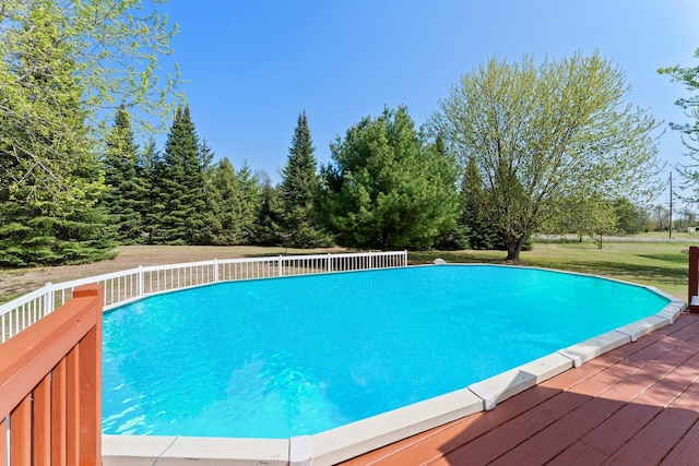 swimming pool with a deck and a yard