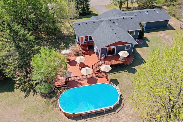view of swimming pool featuring a deck, stairway, and a yard