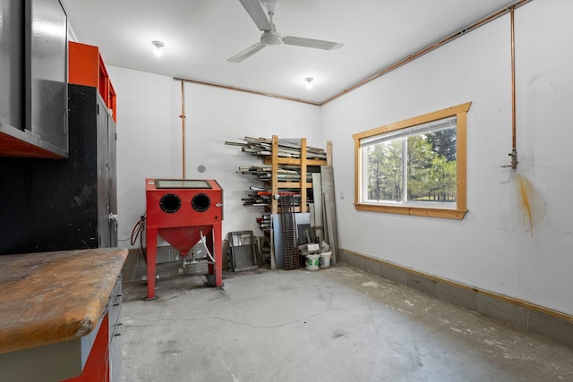 miscellaneous room with a ceiling fan, concrete floors, and a workshop area