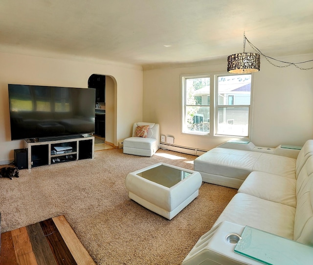 living room featuring a baseboard radiator, arched walkways, and wood finished floors