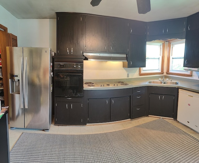 kitchen featuring white appliances, a sink, under cabinet range hood, and light tile patterned floors