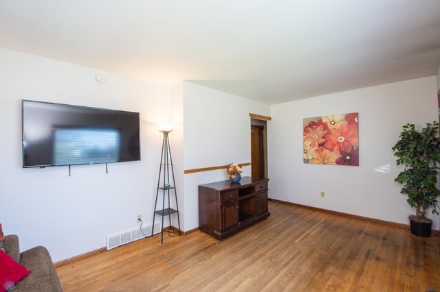 living area with light wood-type flooring and baseboards