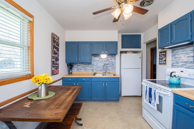 kitchen featuring white appliances, a sink, blue cabinets, and tasteful backsplash