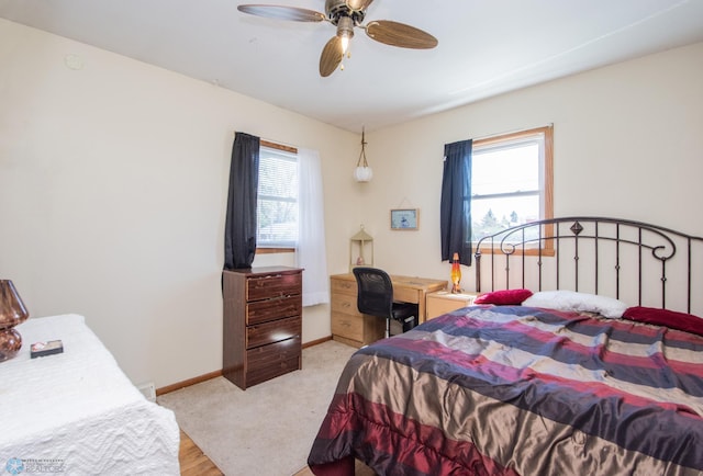 bedroom featuring baseboards, ceiling fan, and light colored carpet