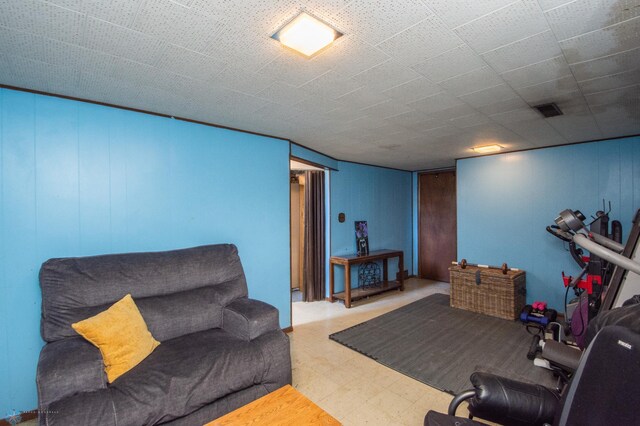living area featuring tile patterned floors and wooden walls