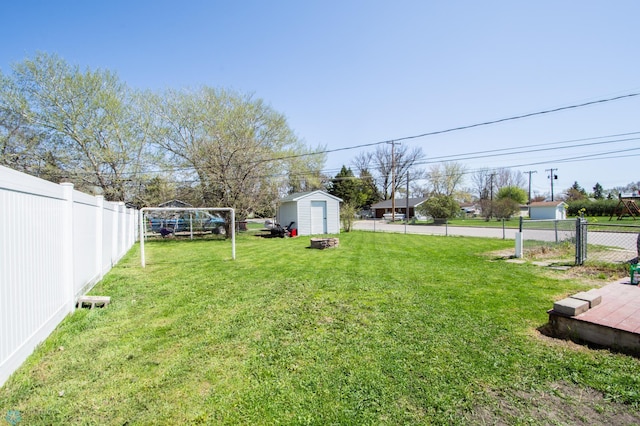view of yard featuring a storage unit, an outbuilding, and a fire pit