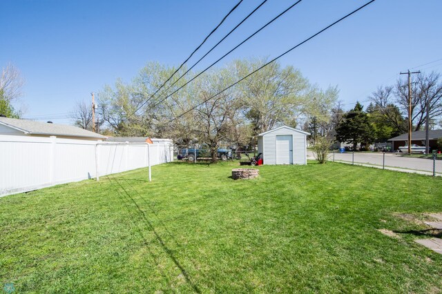 view of yard with a shed, an outdoor structure, and a fire pit