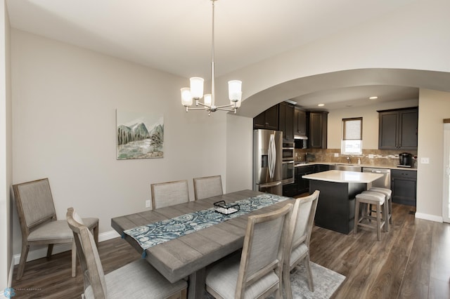3313 5th Way E Unit B, West Fargo, ND 58078 - dining space with arched walkways, dark wood-style flooring, a chandelier, baseboards, and recessed lighting