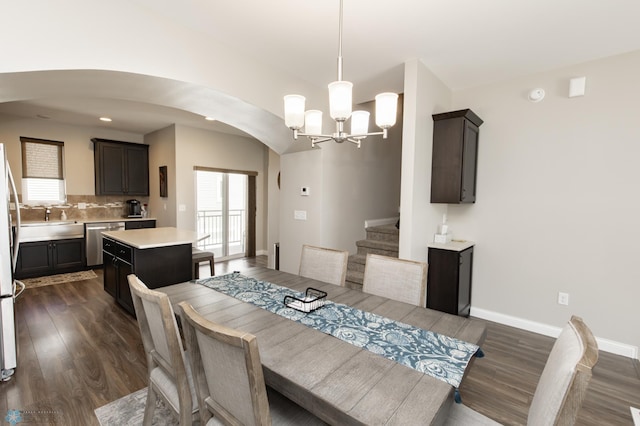3313 5th Way E Unit B, West Fargo, ND 58078 - dining room with arched walkways, dark wood-style flooring, a chandelier, and baseboards