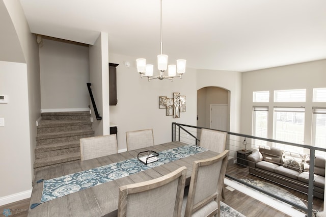 3313 5th Way E Unit B, West Fargo, ND 58078 - dining area featuring wood finished floors, a chandelier, arched walkways, baseboards, and stairway
