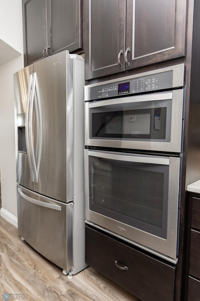 3313 5th Way E Unit B, West Fargo, ND 58078 - kitchen featuring appliances with stainless steel finishes, light wood-type flooring, dark brown cabinetry, and baseboards
