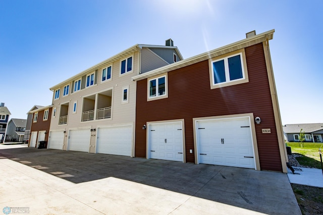 3313 5th Way E Unit B, West Fargo, ND 58078 - back of house with an attached garage, concrete driveway, and a residential view