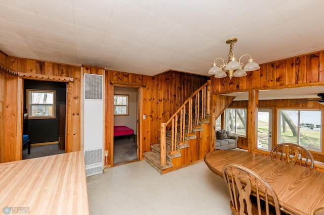 20841AND20850 Leona Beach Rd, Erie Twp, MN 56578 - unfurnished dining area featuring a heating unit, wood walls, a chandelier, plenty of natural light, and stairs