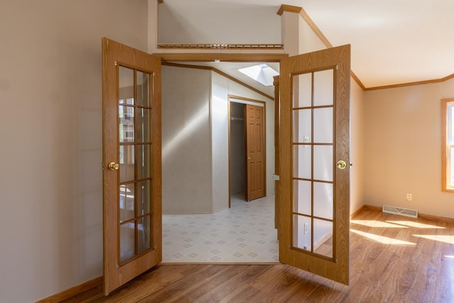 36308 Edgewood Rd, Harmony, MN 55939 - empty room featuring french doors, wood finished floors, a skylight, baseboards, and lofted ceiling