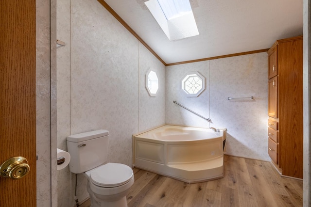 36308 Edgewood Rd, Harmony, MN 55939 - bathroom featuring wood finished floors, a skylight, crown molding, a garden tub, and toilet