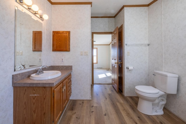 36308 Edgewood Rd, Harmony, MN 55939 - bathroom featuring wood finished floors, ornamental molding, vanity, toilet, and wallpapered walls