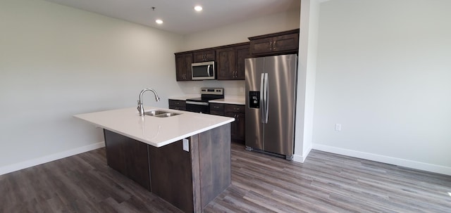 715 Lake Shore Dr NE Unit 207, Bemidji, MN 56601 - kitchen with stainless steel appliances, a sink, baseboards, a kitchen island with sink, and dark brown cabinets
