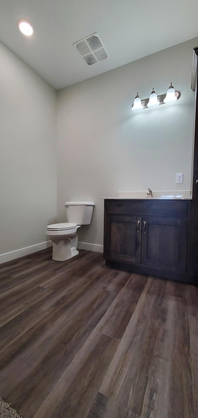 715 Lake Shore Dr NE Unit 207, Bemidji, MN 56601 - bathroom featuring toilet, wood finished floors, baseboards, and vanity