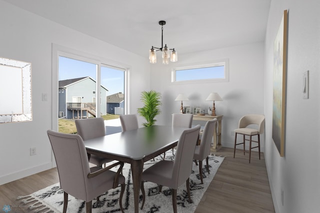 7279 26th St S, Fargo, ND 58104 - dining space featuring a chandelier, light wood-style floors, and baseboards